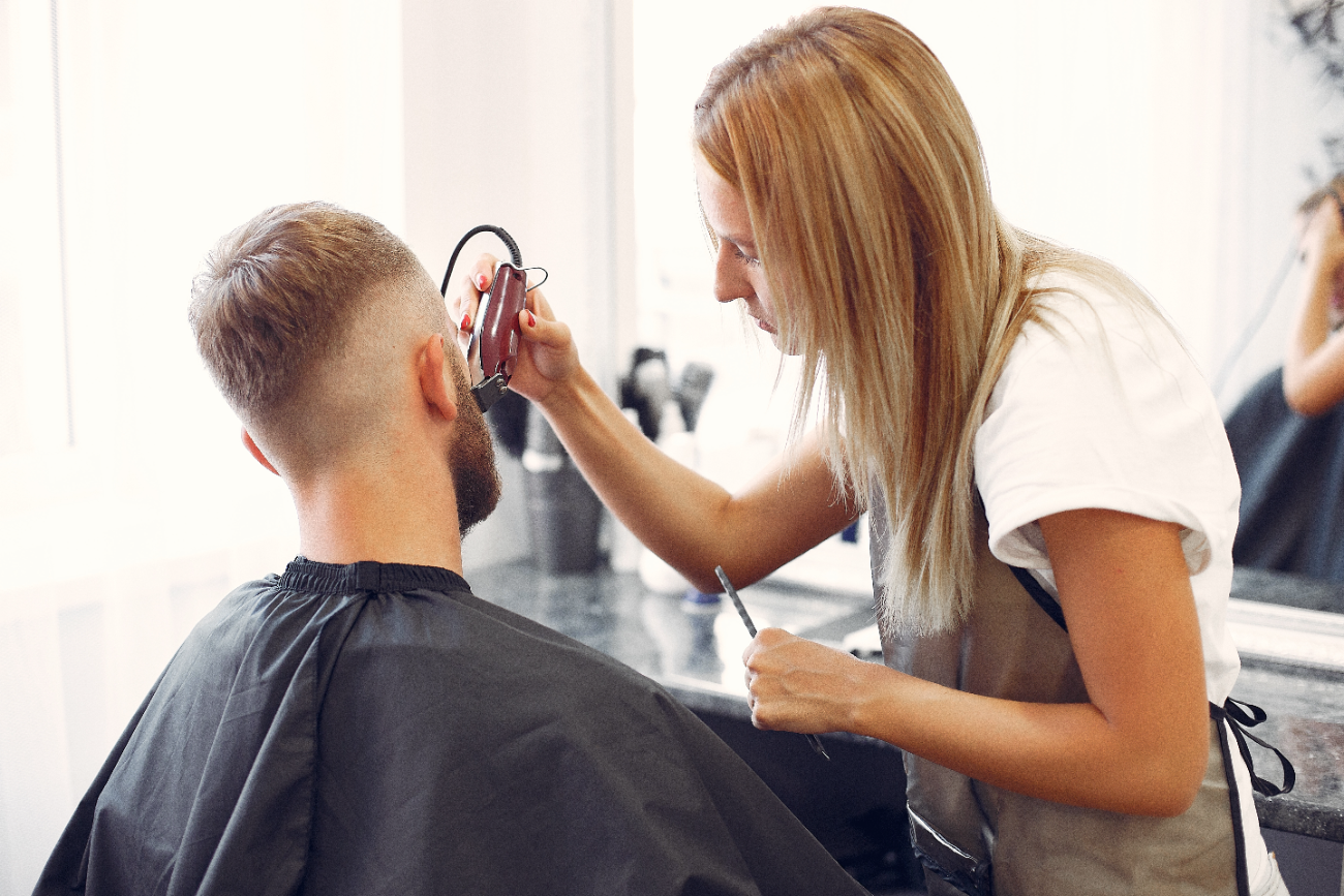 Kapper trimt de baard van een klant in de salon